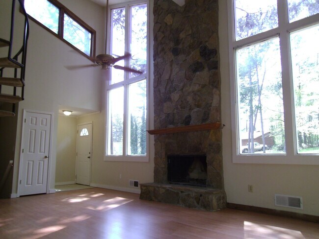 Sala de estar con techo abovedado y chimenea de piedra apilada. - 3466 Winter Hill Drive