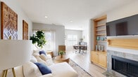 This thoughtfully designed single-floor residence offers a seamless blend of comfort and contemporary style. The open-concept layout connects the living room, dining area, and kitchen, creating a spacious and cohesive living environment throughout. Light hardwood-style flooring runs throughout the main living areas, enhancing the bright and airy atmosphere generated by abundant natural light from multiple windows.

The living room is a welcoming focal point, featuring recessed lighting, neutral gray walls, and generous space for relaxing and entertaining. A built-in shelving unit with warm wood cabinetry adds functional character to the room. The dining area benefits from large windows that frame outdoor views, flooding the space with natural light and providing an inviting setting for meals.

The kitchen is highlighted by a distinctive bay window arrangement that draws in exceptional natural light, complemented by warm wood cabinetry and granite-style countertops offering ample workspace and storage.

The primary bedroom is a calm retreat, carpeted for comfort and featuring a window with sheer curtains that softly filter natural light. A second bedroom, also carpeted, is bright and versatile, with a wide window overlooking the surrounding neighborhood.

The full bathroom is clean and functional, featuring warm wood vanity cabinetry, a large mirror, and a tub-shower combination with tile surround, completing this well-rounded residence.