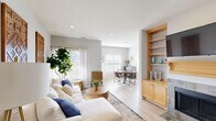 This thoughtfully designed single-floor residence offers a seamless blend of comfort and contemporary style. The open-concept layout connects the living room, dining area, and kitchen, creating a spacious and cohesive living environment throughout. Light hardwood-style flooring runs throughout the main living areas, enhancing the bright and airy atmosphere generated by abundant natural light from multiple windows.

The living room is a welcoming focal point, featuring recessed lighting, neutral gray walls, and generous space for relaxing and entertaining. A built-in shelving unit with warm wood cabinetry adds functional character to the room. The dining area benefits from large windows that frame outdoor views, flooding the space with natural light and providing an inviting setting for meals.

The kitchen is highlighted by a distinctive bay window arrangement that draws in exceptional natural light, complemented by warm wood cabinetry and granite-style countertops offering ample workspace and storage.

The primary bedroom is a calm retreat, carpeted for comfort and featuring a window with sheer curtains that softly filter natural light. A second bedroom, also carpeted, is bright and versatile, with a wide window overlooking the surrounding neighborhood.

The full bathroom is clean and functional, featuring warm wood vanity cabinetry, a large mirror, and a tub-shower combination with tile surround, completing this well-rounded residence.