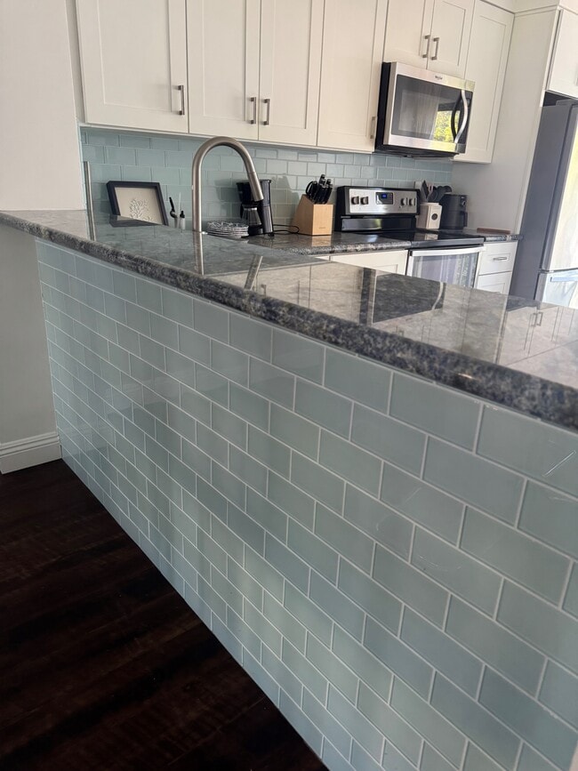 Cocina contemporánea con azulejos tipo metro azules, barra americana y encimeras de granito azul. - 3412 Via Alicante