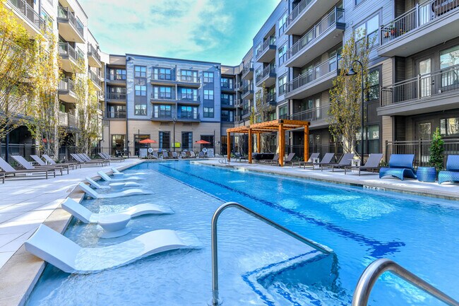 Nuestra piscina está completa con un área de yoga junto a la piscina. - Elevate West Village