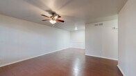 This single-floor, 1-bedroom, 1-bathroom unit in Austin, TX offers an efficient and comfortable layout across a compact but thoughtfully arranged floor plan. The living room serves as the heart of the home, featuring rich wood-look tile flooring, crisp white walls, a ceiling fan with light fixture, and a window that invites natural light and outdoor views—creating a bright and welcoming atmosphere. Decorative wainscoting paneling on one wall adds a subtle architectural touch to the space.

The kitchen is positioned adjacent to the living area, providing a convenient and connected flow. The bedroom is a generously sized retreat, finished with plush carpeting, a ceiling fan, and a window with blinds that allows for natural light while maintaining privacy. The room also provides access to a dedicated walk-in closet outfitted with dual hanging rods, built-in shelving, and carpeted flooring—offering ample storage and organization options.

The full bathroom is clean and functional, featuring wood-look flooring, a single-sink vanity with granite-style countertop, under-sink cabinetry, a large mirror, and a full tub-shower combo with white tile surround. A hallway connects the main areas of the unit, completing this practical and tidy single-story home.
