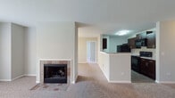 Located at 420 Vinings Dr in Bloomingdale, Illinois, this single-floor residence offers a well-organized layout with functional living spaces throughout. The open-concept living and dining area is a central highlight, featuring plush wall-to-wall carpeting, neutral-toned walls, and a tile-surround wood-burning fireplace that serves as a focal point. A large window floods the living area with natural light and provides views of the surrounding greenery, enhancing the overall sense of openness.

The kitchen is positioned adjacent to the living area and is defined by dark espresso cabinetry, granite-style countertops, and black appliances including a refrigerator and dishwasher. Tile flooring runs throughout the kitchen, offering both practicality and visual contrast to the carpeted living spaces.

The bedrooms are generously sized, each featuring soft carpeting, neutral gray walls, and windows that admit natural light. One bedroom includes a closet with double panel doors, providing ample storage.

Two full bathrooms feature dark vanity cabinetry with light countertops, large mirrors, wood-look tile flooring, and tiled tub-shower combinations with chrome fixtures. The primary bathroom includes an extended vanity with additional counter space. Overall, the residence presents a cohesive, neutral palette with clean finishes throughout.