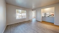 Located at 1401 Pennsylvania St NE in Albuquerque, New Mexico, this two-bedroom, one-bathroom unit offers a practical and well-organized single-floor layout. Light wood-style flooring runs consistently throughout the home, complementing the clean white walls and textured ceilings to create a bright, neutral aesthetic.

The spacious living room receives natural light through a large window and features ceiling vents for climate control. It flows into a combined kitchen and dining area, where the kitchen is equipped with an electric range, a stainless steel sink, ample gray cabinetry with white countertops, and a generously sized pantry closet.

Both bedrooms are comfortably sized, each featuring double-door closets and windows that bring in natural light. The primary bedroom offers a notably generous footprint. An additional five closets are distributed throughout the unit, providing exceptional storage capacity.

The bathroom is elongated in layout, featuring wood-style flooring, a vanity with dark cabinetry and a white countertop, a large mirror, and a shower-tub combination with a curtain. A dedicated laundry area and a connecting hallway complete the floor plan. The unit also includes a dedicated hallway connecting the main living areas to the bedrooms and bathroom, adding to the home's functional flow.