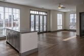 Located at 355 Walnut St in Chattanooga, Tennessee, this single-floor unit offers a thoughtfully designed layout with contemporary finishes throughout. The open-concept living and dining area is bathed in natural light through large floor-to-ceiling windows fitted with plantation shutters, and is complemented by light hardwood flooring and a ceiling fan overhead. French-style doors provide direct access to an outdoor balcony, adding an inviting connection to the surrounding urban environment.

The kitchen is well-equipped with stainless steel appliances, including a refrigerator, electric range, over-the-range microwave, and dishwasher. Crisp white shaker-style cabinetry extends to the ceiling for ample storage, while granite countertops and a clean subway tile backsplash complete the polished look.

The bedrooms feature plush carpeting, ceiling fans, generous closet space, and large windows that fill each room with natural light and views of the city streetscape. A secondary room with light wood flooring offers flexible use as an office or additional bedroom.

The bathrooms are finished with granite-topped vanities, wood-look flooring, and white tile surrounds. One bathroom features a walk-in shower with a sliding glass door, while another includes a soaking tub and shower combination. The overall aesthetic is clean, modern, and move-in ready.