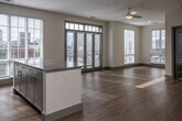 Located at 355 Walnut St in Chattanooga, Tennessee, this single-floor unit offers a thoughtfully designed layout with contemporary finishes throughout. The open-concept living and dining area is bathed in natural light through large floor-to-ceiling windows fitted with plantation shutters, and is complemented by light hardwood flooring and a ceiling fan overhead. French-style doors provide direct access to an outdoor balcony, adding an inviting connection to the surrounding urban environment.

The kitchen is well-equipped with stainless steel appliances, including a refrigerator, electric range, over-the-range microwave, and dishwasher. Crisp white shaker-style cabinetry extends to the ceiling for ample storage, while granite countertops and a clean subway tile backsplash complete the polished look.

The bedrooms feature plush carpeting, ceiling fans, generous closet space, and large windows that fill each room with natural light and views of the city streetscape. A secondary room with light wood flooring offers flexible use as an office or additional bedroom.

The bathrooms are finished with granite-topped vanities, wood-look flooring, and white tile surrounds. One bathroom features a walk-in shower with a sliding glass door, while another includes a soaking tub and shower combination. The overall aesthetic is clean, modern, and move-in ready.