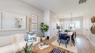 This thoughtfully designed single-story home offers 2 bedrooms and 1 bathroom across a comfortable, efficiently laid-out floor plan. The open-concept living, dining, and kitchen area forms the heart of the home, bathed in natural light from multiple windows. Light-toned walls and durable wood-look flooring run throughout, creating a cohesive and airy aesthetic.

The kitchen is a standout feature, showcasing white shaker cabinetry, a subtle tile backsplash, stainless steel appliances, and a spacious quartz-topped island with an undermount sink and matte black faucet. Glass pendant lights hang above, adding a refined touch. The adjacent dining area accommodates a full dining table, making the space ideal for entertaining.

The living room offers generous natural light through large windows and flows seamlessly into the dining area. The primary bedroom is a well-proportioned retreat featuring dual windows, light-filtering curtains, and direct access to the bathroom. The second bedroom is equally bright and comfortable. The shared bathroom is finished with large-format tile, a sliding glass-enclosed shower, a white vanity with quartz countertop, and coordinating matte black fixtures. A hallway connects the rooms efficiently, completing this clean and modern single-floor layout.