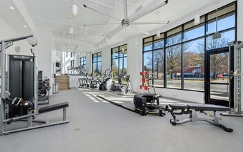 Gym with Cable Weights, Treadmills, and Expansive Street-Facing Windows - NoDa Flats