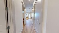 Located in Tampa, FL, this thoughtfully designed one-bedroom, one-bathroom residence offers a modern and efficient layout with high-end finishes throughout. Light-toned luxury vinyl plank flooring runs continuously from the entry hallway through the main living areas, creating a cohesive and clean aesthetic. The hallway, lined with crisp white panel doors and a sliding barn door, leads seamlessly into the heart of the home.

The kitchen and living area share an open-plan layout. The kitchen features white shaker-style cabinetry, quartz countertops, stainless steel appliances, an under-mount sink, and a striking herringbone tile backsplash, complemented by open shelving for added functionality. The living room is anchored by a bold teal accent wall and large windows that frame sweeping waterfront views, filling the space with abundant natural light.

The bedroom is a cozy retreat accented by a deep teal feature wall, a clerestory window, built-in closets, and warm wood-toned furnishings. The bathroom is finished in crisp white subway tile with a tub-shower combination, a single-sink vanity with ample storage, and light-toned tile flooring, maintaining the clean, contemporary feel found throughout the residence.