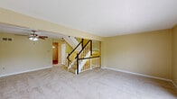 Located at 4000 Wellington Drive in Oakdale, PA, this three-floor home offers a well-organized layout across its levels. The ground floor houses a single-car garage with concrete flooring, an automatic door opener, and an electrical panel, along with a utility room for added convenience. The main living level features a spacious carpeted living area bathed in natural light, with a staircase finished in white balusters and dark wood handrails serving as a central architectural element. The kitchen is well-appointed with dark cabinetry, granite-style countertops, stainless steel appliances, hardwood flooring, and a large window overlooking lush greenery. A hallway with closet storage connects the kitchen to the main living space. The upper floor hosts all three bedrooms, each finished with plush carpet and neutral-toned walls. The generously sized primary bedroom features vaulted ceilings with a ceiling fan and offers a quiet, comfortable retreat. Additional bedrooms include closet storage and windows with tree-lined views. The two bathrooms are finished with hardwood flooring, dark vanity cabinetry, and octagonal windows that bring in soft natural light. Throughout the home, warm neutral tones and natural light create a cohesive and inviting atmosphere.