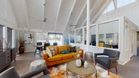 Located at 8200 Worthington Galena Rd in Westerville, Ohio, this single-floor property combines striking architectural character with practical, well-appointed interiors. The standout feature of the main living area is its dramatic vaulted ceiling with exposed white-painted wooden beams, which soars overhead and creates an airy, expansive atmosphere. Dual ceiling fans provide efficient air circulation throughout the space. Large windows and a glass-panel wall flood the living area with abundant natural light while offering views of the surrounding exterior. The living space is designed for both comfort and style, flowing seamlessly into a dining area, making it well-suited for everyday living and entertaining. The kitchen is thoughtfully designed with white shaker-style cabinetry, dark countertops, a classic subway tile backsplash, and stainless steel appliances including a gas range, dishwasher, and refrigerator. Rich hardwood-style flooring runs throughout, adding warmth and cohesion across the space. A dedicated laundry area includes a full-sized washer and dryer with overhead shelving for added storage convenience. The overall ambiance balances modern design sensibilities with a welcoming, functional layout, making this a well-rounded and distinctive property in the Westerville area.