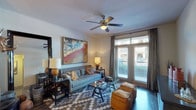 This single-story, one-bedroom, one-bathroom residence offers a thoughtfully designed layout with contemporary finishes throughout. The living room serves as the centerpiece of the unit, featuring rich hardwood-style flooring, a ceiling fan with light fixture, and large French doors that open to a private balcony, flooding the space with natural light. Neutral walls provide a versatile backdrop complemented by the warm, inviting atmosphere of the room.

The kitchen is well-equipped with dark espresso cabinetry, granite countertops, a green tile backsplash, and a full suite of stainless steel appliances, including a refrigerator, range, built-in microwave, and dishwasher. The generous counter space and ample cabinetry make it highly functional.

The bedroom is a comfortable retreat with plush carpeting, a ceiling fan, and windows with balcony access that invite natural light. The bathroom features dark wood cabinetry with granite countertops, a wide vanity with an undermount sink, a large mirror, and a tub-shower combination with tile surround. Consistent finishes across all rooms create a cohesive, polished aesthetic throughout the residence.