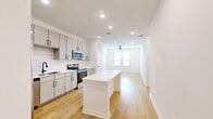 This well-appointed 2-bedroom, 2-bathroom single-story residence at 601 Graham Dr in Sherman, Texas offers a clean, modern aesthetic carried consistently throughout the home. Light wood-tone flooring runs seamlessly across the entire floor plan, complementing the crisp white walls and recessed lighting that keep the interiors bright and welcoming.

The open-concept kitchen is a standout feature, equipped with stainless steel appliances including a refrigerator, range, and microwave, all set against soft gray shaker-style cabinetry with matte black hardware and a classic white subway tile backsplash. A central white kitchen island provides additional prep space and a natural gathering point that flows directly into the living area, which is fitted with a ceiling fan and windows that invite natural light.

Both bedrooms are comfortably sized, featuring ceiling fans or recessed lighting, windows with blinds, and dedicated walk-in closets outfitted with multi-rod shelving systems offering generous storage capacity. The primary bedroom provides a well-proportioned layout suitable for a full furniture arrangement.

The bathrooms are finished in a clean, contemporary style. One bathroom features a full soaking tub with a white subway tile surround and matte black fixtures, adding a refined touch. The overall design of the home prioritizes functionality and modern simplicity, making it a well-organized and move-in-ready living space.