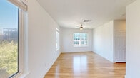 Located at 413 Navasota St in Austin, TX, this efficiently designed 2-bedroom, 1-bathroom home offers a clean, modern aesthetic throughout its single floor. Light hardwood flooring runs continuously through every room, creating a cohesive and airy feel. The layout is anchored by a galley-style kitchen equipped with dark cabinetry, stainless steel appliances including a refrigerator and range, and a functional corridor that connects the living areas seamlessly.

Both bedrooms are bright and well-proportioned, each featuring ceiling fans, crisp white walls, and large windows that invite natural light and offer views of the surrounding Austin cityscape. The primary bedroom includes a dedicated walk-in closet with dual hanging rods and built-in shelving, providing practical storage. The second bedroom is equally well-lit, with its own ceiling fan and a sizable window framing outdoor views.

The bathroom maintains the home's clean design language, with white subway tile in the glass-enclosed shower, wood-look flooring, and brushed nickel fixtures. Two hallways help organize the flow of the space, keeping each area clearly defined. Overall, the home presents a minimalist, move-in-ready environment well-suited to urban Austin living.