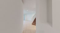 This two-story home offers a thoughtfully designed layout across two levels, combining functional living spaces with clean, neutral finishes throughout. The main level features large-format light tile flooring that extends through the living and common areas, complemented by recessed lighting that keeps the spaces bright and welcoming. A staircase with a white wood railing connects the two floors, adding a classic architectural detail to the interior. Sliding glass doors in the main living area open directly to an outdoor patio, allowing for seamless indoor-outdoor living and an abundance of natural light.

The kitchen is a standout feature, showcasing rich dark cherry wood cabinetry, granite countertops, a stainless steel sink, and white appliances including a range and built-in microwave. The upper level bedrooms are finished with warm wall-to-wall carpeting and feature windows that bring in generous natural light. The bathrooms vary in configuration: one includes a tub-shower combination with tile surround and natural light from a window, while the primary bathroom offers a large soaking tub, a vanity with warm wood cabinetry, and an oversized window. A dedicated laundry room with a full-size washer and dryer rounds out the practical amenities of this well-equipped home.