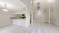 Located at 13401 North 50th Street in Tampa, FL, this two-story, 4-bedroom, 4-bathroom home offers a well-organized layout spread across two floors. The main level features an open-concept living, dining, and kitchen area with soaring double-height ceilings that create a dramatic sense of volume. The kitchen is well-appointed with granite countertops, white shaker-style cabinetry, a tile backsplash, and a full suite of stainless steel appliances including a refrigerator, range, microwave, and dishwasher. Light-colored tile flooring runs throughout the main living areas, complementing the bright, airy atmosphere. A sliding glass door provides direct access to the patio, filling the dining area with natural light. The upper level, accessible via a staircase visible from the main living area, hosts additional bedrooms and bathrooms. Bedrooms are carpeted and feature windows with views of lush Florida greenery. The bathrooms are finished with granite vanity tops and white cabinetry. In-unit washer and dryer hookups add everyday convenience. With five closets distributed throughout the home, storage is plentiful. The overall aesthetic is clean and neutral, making this Tampa home a functional and comfortable residence.