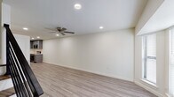 This well-appointed two-story home in Gonzales, Louisiana offers a thoughtfully designed layout with two bedrooms, two full bathrooms, and a convenient half bath. The main level features an open living area with light wood-look vinyl plank flooring, recessed lighting, and a ceiling fan, creating a bright and comfortable gathering space that flows seamlessly into the kitchen. The kitchen is a standout feature, showcasing gray shaker-style cabinetry, crisp white quartz countertops, a stainless steel undermount sink, and a full suite of stainless steel appliances including a range, microwave, and dishwasher. Upstairs, both bedrooms are generously sized, each with wood-look flooring, ceiling fans, and windows with blinds that allow for natural light. Each bedroom benefits from its own private en-suite bathroom, with consistent gray vanity cabinetry and white countertops that match the home's modern aesthetic. The bathrooms are clean and functional, finished with neutral tile flooring. A half bath serves guests on the main level. Throughout the home, clean white walls, panel-style doors, and cohesive finishes contribute to a fresh, contemporary ambiance ideal for comfortable everyday living.