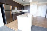 Located at 800 Crawford Street in Portsmouth, Virginia, this single-floor residence offers a thoughtfully designed layout with modern finishes throughout. The kitchen is a standout feature, showcasing dark espresso cabinetry, granite countertops, stainless steel appliances, a subway tile backsplash, and light hardwood-style flooring. A peninsula with pendant lighting provides additional counter space and serves as a natural transition to the living areas. In-unit laundry is conveniently tucked just off the kitchen. The bedrooms are carpeted for comfort and feature ceiling fans, neutral wall tones, and windows that invite natural light and outdoor views. The primary bedroom connects directly to an en-suite bathroom, which includes a dual-sink vanity with granite countertops, dark wood cabinetry, tile flooring, a soaking tub, and access to a walk-in closet. A secondary bathroom mirrors the quality finishes, offering a granite-topped vanity and a tub-shower combination. Crown molding accents select rooms, adding an elevated architectural touch. Throughout the space, the warm, neutral color palette and consistent use of quality materials create a cohesive and inviting atmosphere well-suited for comfortable everyday living.