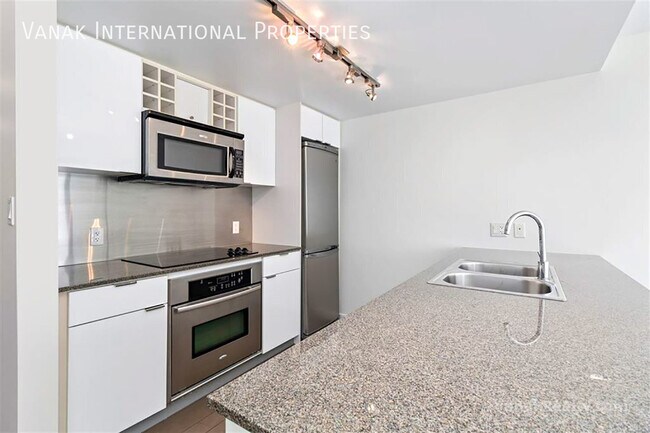 Photo du bâtiment - Bright Downtown 1-Bedroom + Large Den with Parking