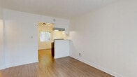 Located on Lakewood Blvd in Downey, CA, this single-story 2-bedroom, 1-bathroom unit offers a well-organized layout with a clean, modern aesthetic. Light wood-style flooring runs consistently throughout the space, complementing the crisp white walls and creating a bright, cohesive feel.

The combined dining and living area serves as the central hub of the home, featuring an open sightline into the kitchen through a half-wall pass-through. The kitchen is a standout, outfitted with white shaker-style cabinets, matte black hardware, light quartz countertops, a deep double-basin sink with a professional-style faucet, and a stainless steel refrigerator. A window above the dining area brings in natural light.

Both bedrooms are well-proportioned and finished with the same warm flooring. The primary bedroom includes a ceiling fan and a mirrored sliding closet door, adding depth to the room. The second bedroom also features a ceiling fan and a wide window with natural light. Three closets throughout the unit provide ample storage.

The bathroom is clean and functional, featuring a tub-shower combination with a window, a modern white vanity with a single-basin sink, and a medicine cabinet mirror. A hallway connects the main living areas to the bedrooms and bath, ensuring an efficient flow throughout this well-appointed home.