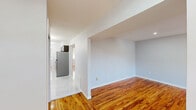 Located at 2211 Country Ln in Ewing, NJ, this thoughtfully renovated two-bedroom, one-bathroom single-floor home offers a clean, modern aesthetic throughout. Warm-toned hardwood floors run consistently across the living areas and bedrooms, creating a cohesive and inviting atmosphere.

The kitchen stands out as a highlight of the home, featuring dark shaker-style cabinetry, light quartz countertops with a tile backsplash, a stainless steel sink, and a full suite of stainless steel appliances including a gas range, over-the-range microwave, and refrigerator. A contemporary multi-arm chandelier adds a stylish finishing touch, while a window provides natural light and a view of the outdoors.

The living room is bright and open, illuminated by recessed lighting and featuring neutral gray walls that complement the hardwood floors. A structural beam detail adds architectural interest to the space.

Both bedrooms are well-proportioned, with the spacious primary bedroom offering recessed lighting and ample room. Each bedroom includes a closet with built-in shelving and hanging rods. The second bedroom features a window overlooking a green outdoor area, bringing in natural light and pleasant views.

The bathroom is finished with elegant marble-style tile surrounding a full soaking tub and shower combination, lending a refined, spa-like quality to the space.