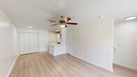 Located at 9888 United Dr in Houston, TX, this two-story unit is thoughtfully laid out across two equally sized floors, offering a practical and comfortable living arrangement. Light wood-style flooring runs throughout both levels, creating a clean, cohesive aesthetic that enhances the sense of openness.

The ground floor hosts a combined kitchen and living area. The kitchen is outfitted with white cabinetry, light stone countertops including a peninsula, a stainless steel sink, black appliances — including an electric range, dishwasher, and refrigerator — and a skylight-style overhead fixture that keeps the space well-lit. The adjacent living area benefits from a large picture window that invites natural light and outdoor views, complemented by a ceiling fan with a built-in light fixture.

The second floor features a dedicated living room with large windows framing lush outdoor scenery, along with a ceiling fan to maintain airflow. A full bathroom on this level includes a combined shower and soaking tub with white tile surround. A closet provides additional storage. A staircase connects both floors seamlessly.

Throughout the unit, the clean white walls and light flooring contribute to a bright, airy ambiance that feels welcoming and move-in ready.