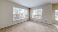 Located at 21759 SE Cedar Brook Way in Sherwood, Oregon, this one-bedroom, two-bathroom unit offers a well-designed single-level layout that maximizes every square foot of its compact footprint. The open-concept living, dining, and kitchen area forms the heart of the home, with tile flooring transitioning seamlessly into plush carpeting in the living space. Recessed lighting illuminates the area, while a window brings in natural light.

The kitchen is efficiently appointed with warm wood cabinetry, granite-style countertops, a breakfast bar with seating, a stainless steel sink, and black appliances including an electric range and refrigerator — providing ample storage and prep space.

The bedroom is a comfortable retreat featuring soft carpet, a ceiling fan, and two large windows that frame views of lush outdoor greenery, filling the room with natural light. Two closets provide generous storage throughout the unit.

Both bathrooms are finished with tile flooring, wood vanities with granite countertops, and clean, neutral tones. One bathroom includes a full soaking tub. A dedicated laundry room houses a full-size washer and dryer, adding everyday convenience. The layout also includes a hallway connecting the private areas of the home, contributing to a functional and well-organized flow throughout.