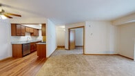This single-floor residence on Jeanne Court in Wood Dale, Illinois offers a well-organized layout with a thoughtful blend of finishes throughout. The galley-style kitchen is a functional highlight, featuring rich wood cabinetry, granite countertops, a stainless steel double sink, and a full suite of stainless steel appliances including a gas range, refrigerator, microwave, and dishwasher. Light wood flooring runs through the kitchen, which is brightened by overhead panel lighting and a ceiling fan. The kitchen opens toward the living area, which transitions seamlessly from hardwood-style flooring to plush wall-to-wall carpeting, creating a comfortable and defined space. Warm-toned wood trim and baseboards carry consistently throughout the unit, lending a cohesive feel. The bedrooms are carpeted and receive natural light through multi-pane windows with blinds, offering views of the surrounding neighborhood. The bathroom is finished with large-format beige travertine-style tile surrounding the soaking tub and shower combination, complemented by chrome fixtures. Neutral wall tones throughout contribute to a clean, versatile aesthetic. The unit is located in the established suburban community of Wood Dale, providing a quiet residential setting.