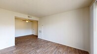 Located at 3816 N 83rd Ave in Phoenix, Arizona, this single-floor residence offers two bedrooms and two bathrooms within a practical and well-organized layout. Wood-look flooring runs consistently throughout the home, lending a cohesive and clean aesthetic to every room. The living area is open and bright, featuring a textured ceiling, a ceiling fan with light fixture, and a front entry door that welcomes natural light into the space. An open sightline connects the living area to the kitchen, which is appointed with white cabinetry, light stone-toned countertops, and white appliances including a refrigerator, electric range, and built-in microwave. Both bedrooms are comfortably proportioned, with the primary bedroom offering generous closet space via sliding doors. Each bedroom benefits from natural light provided by windows with blinds. The two bathrooms mirror each other in design, each featuring a white vanity with a speckled countertop, a large mirror, and wood-look flooring. One bathroom includes a shower/tub combination. A connecting hallway ties the bedrooms and bathrooms together efficiently. Throughout the home, neutral white walls and consistent finishes create a clean, move-in ready environment.