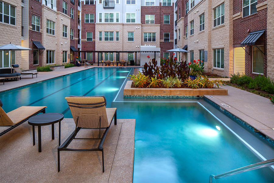 Piscina estilo centro turístico con terraza - District at Greenbriar