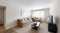 Located at 6600 Rivers Ave in North Charleston, South Carolina, this single-floor residence offers a thoughtfully designed layout with a warm, neutral color palette throughout. The living room features plush carpeting, soft natural light through large windows dressed with sheer curtains, and ample space for comfortable seating arrangements. Adjacent to the living area, the dining space is appointed with wood-look flooring and a ceiling fan overhead, creating a practical and inviting area for everyday meals. The kitchen is efficiently designed with white cabinetry, a classic subway tile backsplash, laminate countertops, black appliances, and wood-look flooring, providing a clean and functional workspace. The two bedrooms are generously proportioned, each featuring carpeted floors, large windows that allow natural light to fill the rooms, and ample closet space — including a spacious walk-in closet with dual shelving rods and built-in shelves. The bathroom features a tiled tub-shower combination, wood-look flooring, and a white vanity. Neutral wall tones carry consistently throughout the home, lending a cohesive and move-in-ready feel to the entire space.