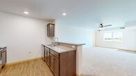 This single-floor, 2-bedroom, 1-bathroom residence offers a practical and comfortable layout designed for everyday living. The open-concept kitchen and living area forms the heart of the home, where rich dark-brown cabinetry, granite-style countertops, and a peninsula with a built-in sink create a functional and attractive workspace. Stainless steel appliances — including a refrigerator, microwave, and range — complement the kitchen's modern aesthetic, while light wood-tone flooring ties the space together seamlessly. The living area extends naturally from the kitchen, featuring plush neutral carpeting and a ceiling fan with integrated lighting, lending a comfortable, relaxed atmosphere.

Both bedrooms are carpeted and filled with natural light from sliding windows that offer outdoor views of the surrounding landscape. The primary bedroom is a generous size and includes a ceiling fan, providing both comfort and airflow. The second bedroom is bright and airy, with its own closet featuring a light wood door. The shared full bathroom is clean and simply appointed, with a tub-shower combination, chrome fixtures, and wood-tone flooring that echoes the rest of the home. Throughout the residence, neutral tones and clean lines create a bright, move-in-ready environment.