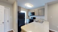 Located at 4075 Alkire Glen Way in Columbus, Ohio, this two-story home offers a well-designed layout suited for comfortable everyday living. The kitchen stands out as a functional and stylish centerpiece, showcasing light quartz countertops with subtle speckled detailing and a peninsula that provides additional prep and seating space. Grey cabinetry lines the walls, complemented by a classic white subway tile backsplash that adds a clean, modern touch. Black appliances — including a refrigerator, electric range, over-the-range microwave, and a stainless steel sink — complete the kitchen's cohesive aesthetic. A window positioned near the range brings in natural light, brightening the workspace. Flush ceiling lighting ensures the kitchen remains well-lit throughout the day and evening. The two-floor layout provides a clear separation between living and sleeping areas, offering both functionality and privacy. The overall design of the home balances contemporary finishes with practical features, creating a space that is move-in ready and easy to personalize. Its Columbus, Ohio location places residents within reach of local amenities, making this a convenient and well-appointed place to call home.