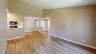 Located at 241 W Buchanan Rd in Pittsburg, CA, this 2-bedroom, 2-bathroom single-floor residence offers a well-organized layout with a functional blend of comfort and practicality. The combined kitchen and living area serves as the heart of the home, where vaulted ceilings lend a sense of openness and light hardwood-style flooring flows throughout. A large front window fills the space with natural light and offers views of the surrounding greenery. The kitchen features light wood cabinetry with ample storage, white countertops, and black appliances including a range, microwave, and refrigerator, alongside a dishwasher and a light wood-style floor. The spacious primary bedroom includes a sliding double-door closet and plush carpeting, with a window framing outdoor views. The second bedroom is equally well-lit with a large window and soft carpet underfoot. Both bathrooms are finished consistently, each offering a tub-shower combo with built-in shelving, a wood-toned vanity with a white countertop, and light wood-style flooring. A hallway connects the bedrooms and bathrooms, completing the efficient and cohesive floor plan. Warm neutral tones and consistent finishes throughout create a clean, inviting ambiance.