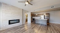 This single-story, 3-bedroom, 2-bathroom home offers a thoughtfully designed open-concept layout that seamlessly connects the living room, dining area, and kitchen. The living room is a standout space, featuring durable wood-look flooring, a ceiling fan, large windows that invite abundant natural light, and a floor-to-ceiling tiled accent wall with a sleek linear fireplace as its centerpiece.

The kitchen is well-equipped for everyday living, boasting rich wood-toned shaker cabinetry, granite-look countertops, a herringbone tile backsplash, stainless steel appliances, and a spacious center island with pendant lighting overhead. A dedicated laundry area with washer and dryer hookups adds everyday convenience.

All three bedrooms are carpeted for comfort and include ceiling fans and windows with natural views. The generously sized primary bedroom offers a comfortable retreat. Both bathrooms are finished with wood-look flooring, granite-topped vanities with dark wood cabinetry, and tub-shower combinations. Two closets provide ample storage throughout the home. The neutral color palette and modern finishes create a clean, cohesive aesthetic throughout the entire space.