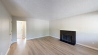 Located at 7806 NE 12th St in Vancouver, WA, this single-floor, 2-bedroom, 1-bathroom home offers a functional and comfortable layout throughout. The living room serves as a welcoming focal point, featuring light hardwood-style flooring, neutral wall tones, a textured ceiling, and a classic dark brick fireplace with a white mantel — an ideal gathering space. Adjacent to the living area, the combined dining room and kitchen maximizes utility. The galley-style kitchen is outfitted with warm wood cabinetry, light countertops, a stainless sink, and black appliances including a refrigerator, stove, and dishwasher. The dining area benefits from natural light through a window overlooking greenery, complemented by a ceiling fan. A central hallway connects the bedrooms, bathroom, and utility room, with three closets providing generous storage. The primary bedroom offers hardwood-style flooring and a dedicated closet, while the second bedroom features plush carpeting and a window that invites natural light. A utility room houses the water heater. Textured ceilings and baseboard heating are consistent throughout, giving the home a cohesive, practical character well-suited for everyday living.
