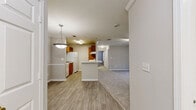 Located in Sugar Hill, Georgia, this thoughtfully laid-out residence features three bedrooms, two full bathrooms, and a practical single-floor design. The living area is highlighted by crown molding, a ceiling fan, and sliding glass doors that open to a private balcony overlooking lush greenery, flooding the space with natural light.

The kitchen is functional and well-appointed, featuring warm wood cabinetry, white appliances including a refrigerator, dishwasher, and electric range, and light hardwood-style flooring that extends through the adjoining areas. Crown molding adds a refined touch to the kitchen and dining space.

The generously sized primary bedroom includes a ceiling fan, a walk-in closet with wire shelving for organized storage, and its own bathroom access. The two additional bedrooms are carpeted and bright, each featuring large windows with outdoor views. One includes a built-in closet with classic paneled doors.

Both bathrooms are clean and functional, with light hardwood-style flooring. One features a full tub-shower combination with crisp white tile surround. A dedicated walk-in closet with multi-level wire shelving provides ample storage. Throughout the home, neutral tones, plush carpeting in the bedrooms, and consistent finishes create a cohesive and comfortable living environment.