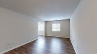 Located at 100 Lochaven Dr in Charleston, SC, this 2-bedroom, 2-bathroom single-floor home offers a practical and well-organized layout. The open living room is bright and spacious, featuring dark wood-look flooring, neutral gray walls, and multiple windows with horizontal blinds that allow ample natural light throughout. The adjoining kitchen is well-equipped with white shaker-style cabinetry, dark granite-look countertops, and black appliances including a range, microwave, refrigerator, and dishwasher, all set over wood-look flooring. The primary bedroom provides a comfortable retreat with soft carpeting, a ceiling fan with light fixture, a closet, and a window overlooking the outdoors. The second bedroom also features carpet, a ceiling fan, and natural light from a window. A secondary room with wood-look flooring and multiple windows offers flexibility as a den or additional living space. Both bathrooms are clean and functional, each featuring a tub-shower combo, a white vanity with dark countertop, and wood-look flooring. A hallway connects the rooms, completing this efficiently designed home in the Charleston, SC area.