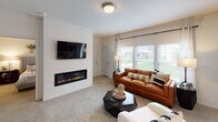 This single-story residence in Broken Arrow, Oklahoma offers a thoughtfully designed layout with comfortable, well-lit living spaces throughout. The living room serves as the heart of the home, anchored by a sleek linear electric fireplace beneath a wall-mounted TV. Large windows flood the room with natural light and provide views of the surrounding greenery, while plush carpet underfoot adds warmth and comfort.

The kitchen is a standout feature, showcasing gray cabinetry paired with striking marble-look countertops that extend to a peninsula with a built-in sink. Stainless steel appliances, including a French door refrigerator, complete the space, making it as functional as it is stylish. Light wood-look flooring ties the kitchen together seamlessly.

The bedrooms are generously sized, each featuring ceiling fans, soft carpeting, and ample natural light from well-placed windows. One bedroom includes a tray ceiling detail and walk-in closet, while another benefits from a corner window arrangement that enhances airflow and brightness.

The bathroom features gray cabinetry, a marble-look vanity countertop, and a well-lit mirror framed by contemporary globe lighting. In-unit laundry is conveniently accessible from the bathroom area. Throughout the home, neutral tones and consistent finishes create a cohesive, modern aesthetic.