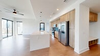 This contemporary 1300 square foot apartment in Atlanta offers a harmonious blend of style and functionality. The open-plan layout seamlessly integrates the living room and kitchen, creating a spacious atmosphere ideal for both relaxation and entertaining. The kitchen boasts sleek wooden cabinetry, stainless steel appliances, and a large island with a built-in sink, perfect for meal preparation and casual dining.

Floor-to-ceiling windows in the living area flood the space with natural light and provide stunning panoramic views of the Atlanta skyline. The apartment features three bedrooms, including a primary bedroom measuring 150 square feet, and three modern bathrooms. One bathroom showcases a clean, minimalist design with white tiled walls, a floating vanity, and a combination bathtub-shower.

Throughout the apartment, warm wood-look flooring contrasts beautifully with the crisp white walls, creating a fresh and inviting ambiance. Practical features include ample closet space with custom shelving and hanging rods. Ceiling fans in the bedrooms offer additional comfort and air circulation.

The property's attention to detail is evident in its high-end finishes, recessed lighting, and thoughtful layout. Located at 10 Tower St NW, this single-story apartment combines urban sophistication with comfortable living, making it an ideal residence in the heart of Atlanta.