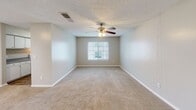 Located at 1910 Honeysuckle Rd in Dothan, Alabama, this single-floor residence offers four bedrooms and three bathrooms within a practical and functional layout. The home features neutral, warm-toned walls and textured ceilings throughout, creating a consistent and understated aesthetic across all rooms.

The expansive primary bedroom provides generous space for furnishing and personalization, with soft carpeting underfoot and a window that allows for natural light. The additional three bedrooms are similarly carpeted, each offering closet access and comfortable proportions suitable for a variety of uses.

The kitchen is designed in a galley style, featuring white cabinetry on both sides, dark-speckled laminate countertops, a white electric range, and wood-look flooring — providing a clean and efficient workspace. Ample upper and lower cabinet storage adds to the kitchen's practicality.

The three bathrooms are finished consistently with white fixtures, including vanities with framed mirrors, well-lit overhead lighting, and tub-shower combinations. The wood-look flooring in the bathrooms complements the overall neutral palette.

A hallway connects the rooms, and a dedicated closet offers additional storage. The exterior, visible in the dollhouse view, shows a multi-unit building setting with surrounding green lawn space. This home delivers a straightforward, functional design well-suited for comfortable everyday living.