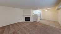 Located at 9730 Old Placerville Rd. in Sacramento, CA, this single-floor residence offers a well-organized layout with a clean, neutral aesthetic throughout. The living area is a standout space, centered around a classic fireplace with a white mantel and finished with wall-to-wall carpet, creating a warm and inviting atmosphere. An open pass-through connects the living area to the kitchen, which features white cabinetry, granite-style countertops, a gas range, a full-size refrigerator, and light wood-look flooring that extends into the adjoining dining or flex space. A ceiling fan with integrated lighting serves this area, adding both function and comfort. The bedroom areas are carpeted and well-lit by natural light through slatted windows, offering a quiet and restful environment. Hallway access leads to a walk-in closet with built-in shelving, providing generous storage. The bathrooms are finished with light wood-look tile flooring and white vanities topped with granite-style counters. One bathroom includes a walk-in glass-enclosed shower, while another offers a clean, functional layout. Textured ceilings are present throughout the unit, consistent with the overall design character of the home.