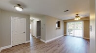 Located at 2 Hollandale Ln in Clifton Park, NY, this single-floor residence offers a well-designed, functional layout with tasteful finishes throughout. The living area is bright and open, featuring warm hardwood-style flooring, neutral-toned walls, and a ceiling fan with integrated lighting. A sliding glass door floods the space with natural light and provides direct access to a private outdoor patio, offering pleasant views of the surrounding greenery.

The kitchen is thoughtfully appointed with grey shaker-style cabinetry, light stone countertops, a hexagonal tile backsplash, and stainless steel appliances including an electric range and over-the-range microwave. A pass-through window connects the kitchen to the main living area, enhancing the open feel of the space.

The bedroom is generously proportioned, bathed in natural light from multiple windows, and includes a ceiling fan. A dedicated walk-in closet provides ample storage. Adjacent to the bedroom is a convenient in-unit laundry area housing a stacked washer and dryer. The bathroom features a full tub-shower combination with tile surround, complemented by neutral wall tones and tile flooring. Clean white millwork and consistent flooring tie the entire residence together cohesively.