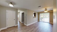 Located at 2 Hollandale Ln in Clifton Park, NY, this single-floor residence offers a well-designed, functional layout with tasteful finishes throughout. The living area is bright and open, featuring warm hardwood-style flooring, neutral-toned walls, and a ceiling fan with integrated lighting. A sliding glass door floods the space with natural light and provides direct access to a private outdoor patio, offering pleasant views of the surrounding greenery.

The kitchen is thoughtfully appointed with grey shaker-style cabinetry, light stone countertops, a hexagonal tile backsplash, and stainless steel appliances including an electric range and over-the-range microwave. A pass-through window connects the kitchen to the main living area, enhancing the open feel of the space.

The bedroom is generously proportioned, bathed in natural light from multiple windows, and includes a ceiling fan. A dedicated walk-in closet provides ample storage. Adjacent to the bedroom is a convenient in-unit laundry area housing a stacked washer and dryer. The bathroom features a full tub-shower combination with tile surround, complemented by neutral wall tones and tile flooring. Clean white millwork and consistent flooring tie the entire residence together cohesively.