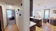 Located at 21155 N 56th St in Phoenix, AZ, this single-floor residence offers a well-designed, open-concept layout with modern finishes throughout. The kitchen is a standout feature, showcasing rich dark cabinetry, light countertops, stainless steel appliances including a refrigerator, dishwasher, microwave, and range, all complemented by light wood-style flooring. A center island with pendant lighting provides additional counter space and seating, flowing seamlessly into the dining and living areas. The living space is bright and airy, with natural light filtering through slatted blinds and a glass door that opens to the exterior. The bedroom is generously sized with plush carpeting, a ceiling fan, and ample natural light. A versatile secondary room serves well as a home office or flex space, featuring carpet flooring and a large window. The bathrooms offer tub/shower combinations with clean tile surrounds and wood-style flooring. A walk-in closet provides extensive storage with built-in shelving and hanging rods. The overall design is contemporary and cohesive, with neutral tones, clean lines, and thoughtful details that create a comfortable and functional living environment.