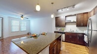 Located at 101 Integra Village Trail in Sanford, Florida, this single-floor residence offers a thoughtfully designed layout with contemporary finishes and a warm, welcoming ambiance. The open-concept kitchen and living area serves as the heart of the home, showcasing rich dark-wood cabinetry, granite countertops, a large central island with pendant lighting, stainless steel appliances, and a subway tile backsplash. Track lighting above the kitchen adds a modern touch, while warm hardwood-style flooring flows seamlessly throughout the main living spaces, enhancing the sense of openness and continuity.

The living area is bright and airy, benefiting from natural light streaming through blinds-fitted windows and accented by crown molding and a ceiling fan overhead. A private entrance door adds convenience and accessibility directly from this space.

The bedrooms are comfortably appointed with plush carpeting, ceiling fans, and generous natural light from well-positioned windows. One bedroom features access to a spacious walk-in closet outfitted with built-in wire shelving, providing abundant storage. The bathroom is clean and functional, featuring dark wood vanity cabinetry, a white countertop, and hardwood-style flooring that ties cohesively into the rest of the home's design aesthetic.