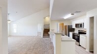 MacAlpine Place Unit 14-304 is a two-story, 2-bedroom, 2-bathroom residence spanning 1,530 square feet, with 1,100 sq ft on the main floor and 430 sq ft on the upper level. The kitchen features stainless steel appliances including a refrigerator, electric range, and over-the-range microwave, complemented by crisp white cabinetry, light countertops, and a curved breakfast bar peninsula. Light wood-style flooring runs through the kitchen and bathrooms, while plush carpeting covers the bedrooms and living areas. Both bedrooms are well-sized, with the primary bedroom measuring 180 sq ft, and each room is equipped with a ceiling fan and natural light from windows with blinds. The primary bedroom features a vaulted ceiling, adding an airy, open feel. Each bathroom includes a vanity with storage, a tub/shower combination, and wood-style flooring. The unit includes three closets with wire shelving systems for organized storage, along with a dedicated in-unit laundry area with a full-size washer and overhead shelving. A hallway and three staircase sections connect the two floors, providing a functional and practical layout throughout this well-appointed residence.