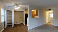 Located at 1175 Mathis Ferry Rd in the desirable Mt Pleasant, South Carolina, this single-floor residence offers a practical and comfortable layout designed for everyday living. The living area features a combination of hardwood-style flooring and carpeting, with a ceiling fan overhead that adds both functionality and a casual charm to the space. A standout architectural detail is the pass-through window connecting the living area to the kitchen, allowing natural sightlines and an open, connected feel between the two spaces. The kitchen is outfitted with warm wood-toned cabinetry, track lighting, and a countertop workspace, making it both efficient and inviting. Adjacent to the kitchen, a utility or laundry area is visible, adding convenience to the floor plan. The interior is finished with clean white trim, crown molding, and neutral wall tones throughout, lending the space a bright and tidy ambiance. The thoughtful layout maximizes the use of the available footprint, ensuring a cohesive flow from room to room. Overall, this Mt Pleasant residence combines functional design with warm finishes in a well-situated location.