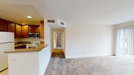 Located at 2265 River Run in San Diego, unit #3205 is a single-floor residence that makes efficient use of its well-organized layout. The open living area is finished with neutral-toned carpet and features a sliding glass door fitted with vertical blinds, allowing natural light to fill the space while providing access to the outdoors. A hallway connects the living area to the private rooms, each of which continues the carpeted flooring and is brightened by windows with views of surrounding greenery.

The kitchen is positioned adjacent to the living area and is defined by warm wood cabinetry, granite-style countertops, and light tile flooring. It is equipped with a full suite of appliances including an electric range, built-in microwave, and refrigerator, along with recessed lighting overhead. A raised breakfast bar separates the kitchen from the main living space.

Two bathrooms serve the unit. One features a shower stall with a wood vanity and granite-style countertop, while the second includes a full tub/shower combination, matching vanity, and tile flooring. Both are finished in a clean, neutral palette. A ceiling light fixture and dedicated entry area round out this functional San Diego residence.