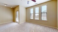 This single-story, one-bedroom, one-bathroom residence offers a thoughtfully designed layout across a compact yet functional floor plan. The open-concept living area is finished with plush neutral-toned carpet and warm beige walls, creating a welcoming ambiance. Track lighting illuminates the space, and a glass door provides access to the exterior, allowing natural light to flow freely throughout.

The kitchen is a standout feature, showcasing rich dark wood cabinetry paired with granite countertops and stainless steel appliances, including a refrigerator, range, and microwave. A peninsula with a built-in sink adds both prep space and a natural dividing point between the kitchen and living areas, while hardwood-style flooring anchors the space with warmth.

The bedroom is generously sized, featuring large multi-panel windows that offer outdoor views and fill the room with natural light. A ceiling fan adds comfort, and plush carpeting continues throughout. A dedicated closet provides practical storage.

The bathroom is finished with tile-surround tub and shower combination accented by a decorative mosaic tile border, complemented by hardwood-style flooring, dark wood cabinetry, and granite countertops that echo the kitchen's refined aesthetic. A separate closet rounds out the unit's storage offerings.